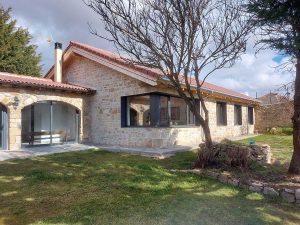 Casa La Introvertida diseñada por Estudio de arquitectura Estévez Michelena en Aguilar de Campoo con fachada de piedra y grandes ventanales